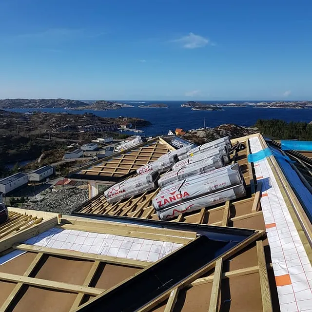Oversikt over tak og kystlandskap i bakgrunnen