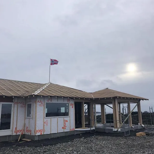Bygg under oppføring med norsk flagg på taket